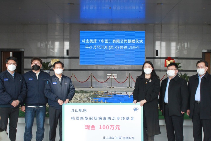 斗山机床总经理金晳俊先 生（左三）代表公司捐赠新冠防治 资金100万元